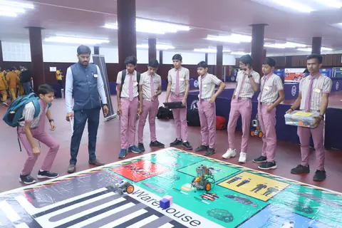 Student teams watching a robot on a competition mat